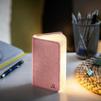 Gingko Design – Lampa Smart Book LED - Len Pudrowy Róż - 2 Rozmiary, lampka biurkowa w kształcie różowej książki, włączona na biurku