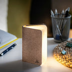 Gingko Design – Lámpara Smart Book LED - Lino Marrón Café - Mini, lámpara de noche en forma de libro abierto, colocada sobre un escritorio