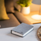 Gingko Design – Lampa Smart Book LED - Len Miejski Szary - 2 Rozmiary, szara książka leżąca na stoliku kawowym w salonie