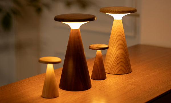 Gingko Design – Lámpara de mesa Sylva - Fresno blanco - 2 tamaños, cuatro lámparas de mesa de madera de diferentes tamaños, encendidas, sobre una mesa de madera