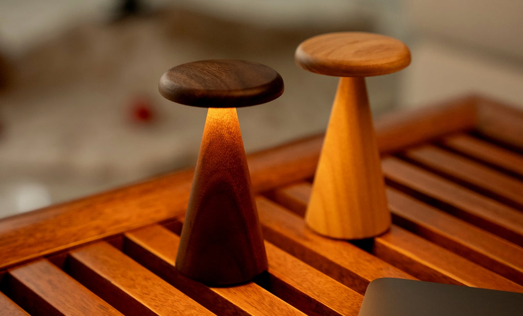 Gingko Design – Sylva Tischleuchte - Weiße Esche - 2 Größen, zwei Tischleuchten aus Holz, eine davon eingeschaltet, auf einem Holztisch