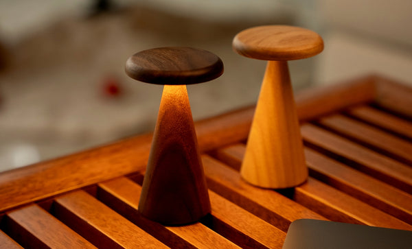 Gingko Design – Lámpara de mesa Sylva - Nogal - 2 tamaños, dos lámparas de mesa de madera, una de ellas encendida, sobre una mesa de madera