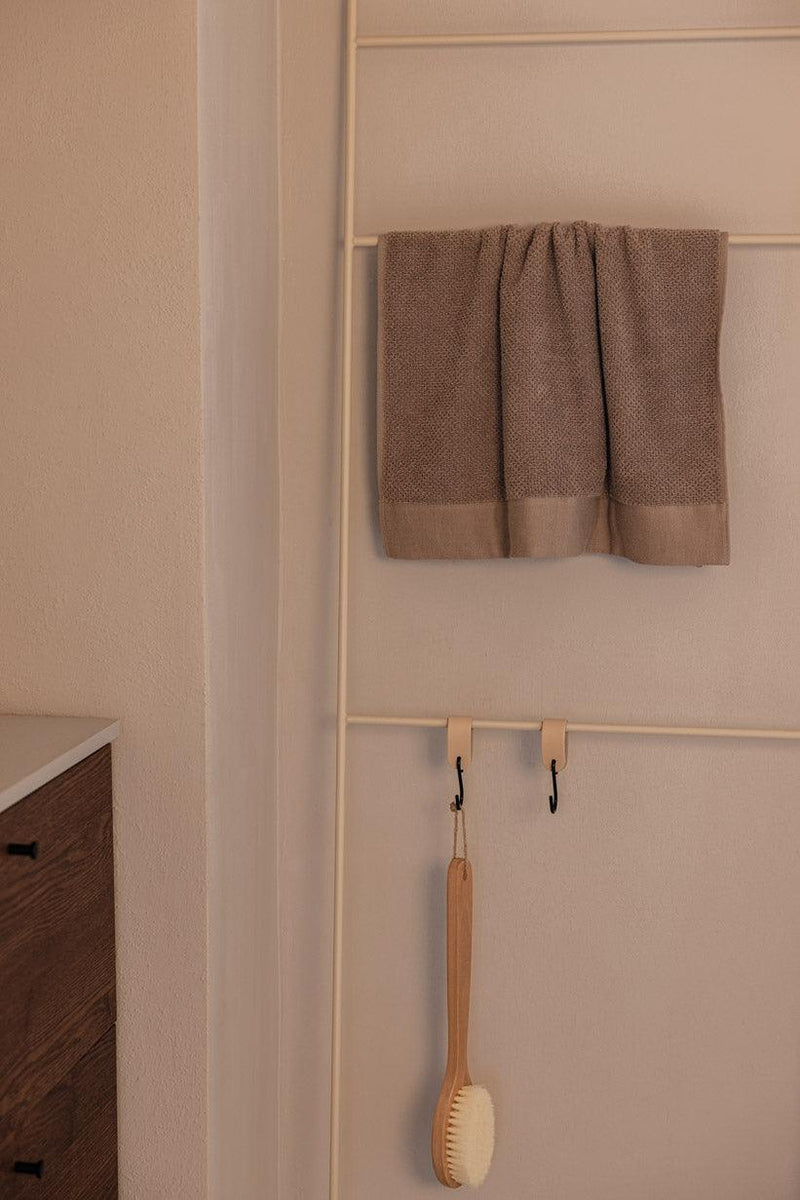 Handtuchleiter mit einem handtuch und einer Bürste, ideal para accesorios de baño.