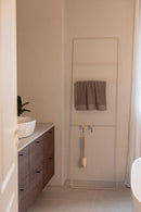 Handtuchleiter Estina im Badezimmer mit Handtüchern und Badutensilien, diseño moderno.
