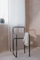 Minimalist Herrendiener JAMES Kleiderständer in einem hellen Schlafzimmer, ideal für Kleidung und Accessoires.