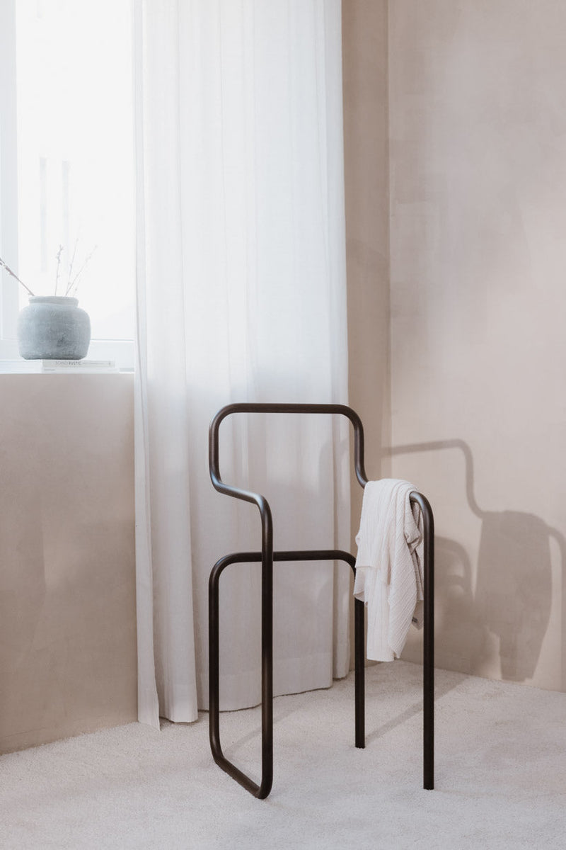 Minimalist Herrendiener JAMES mit heller Kleidung in einem stilvollen Schlafzimmer-Setup.