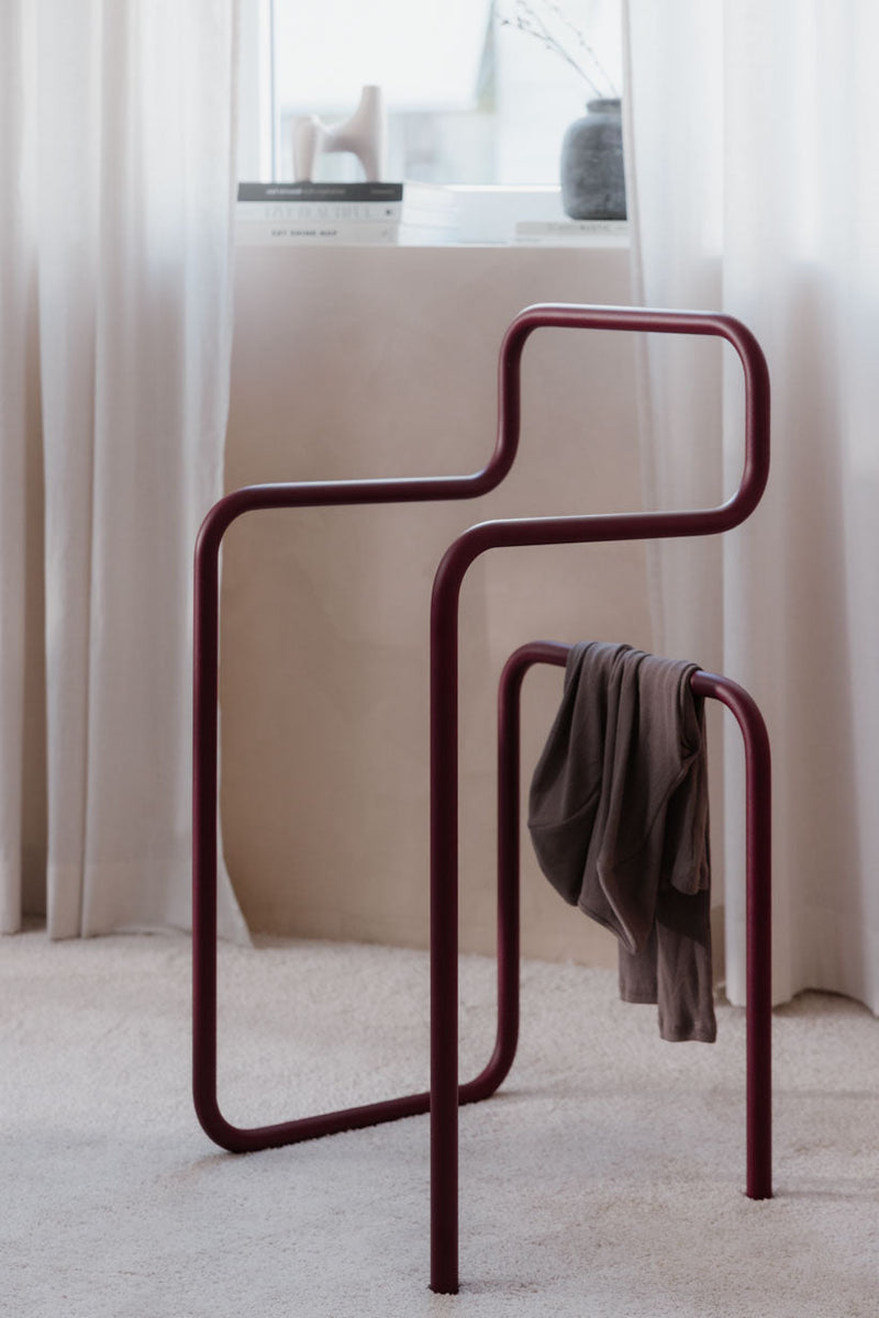 Minimalist Herrendiener JAMES mit lässig drapiertem Kleidungsstück in einem modernen Raum.