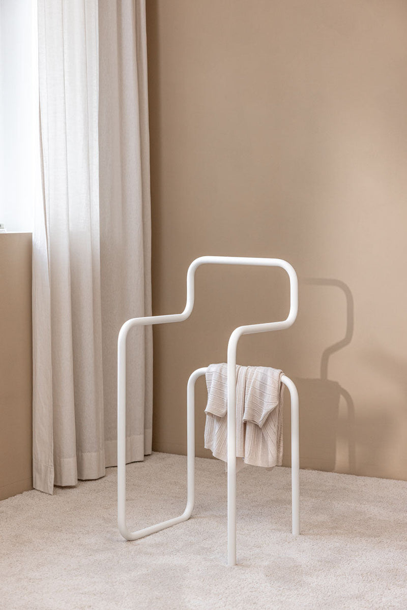 Herrendiener JAMES in minimalistischer Form mit aufgehängtem Kleidungsstück vor einem neutralen Hintergrund.