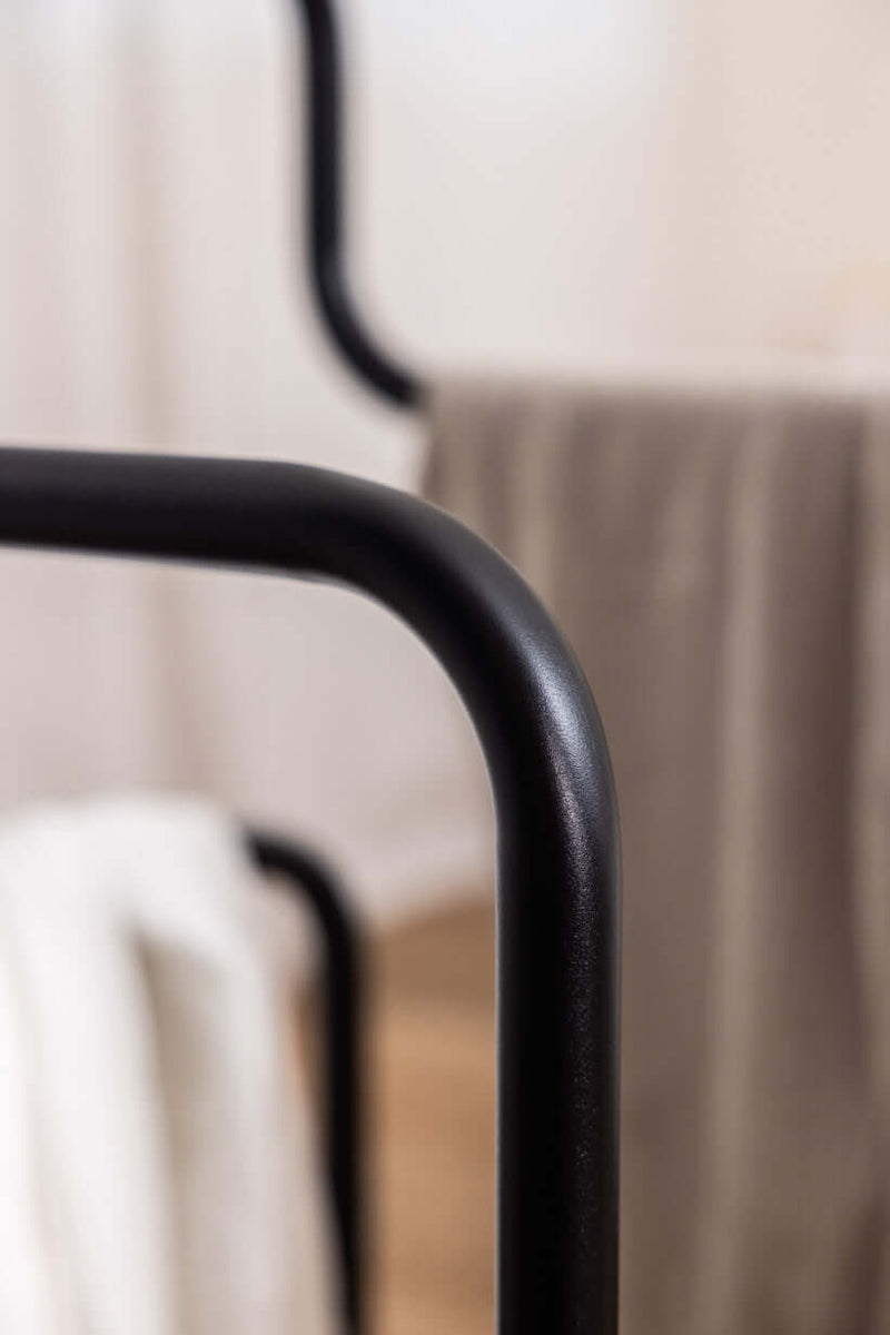 Nahaufnahme des Herrendiener JAMES mit schwarzem Metallrahmen und minimalistischer Gestaltung in einem Ankleidezimmer.