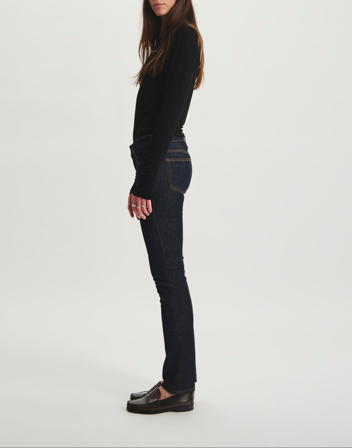 Ines De La Fressange – Jeans Anemone - Grezzo, modella di profilo che indossa jeans grezzi e un top nero