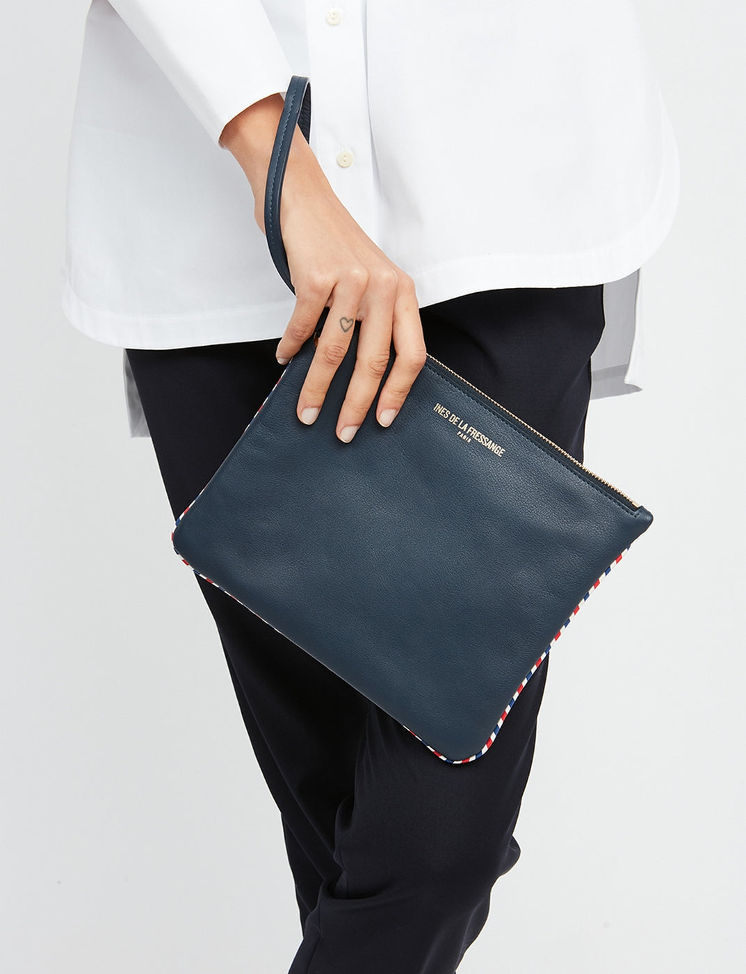 Ines De La Fressange – Marcia Small Leather Goods - Navy, navy blue leather pouch carried by a woman