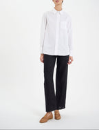 Ines De La Fressange – Camicia Maureen - Bianco, modella che indossa una camicia bianca, pantaloni neri e mocassini marroni