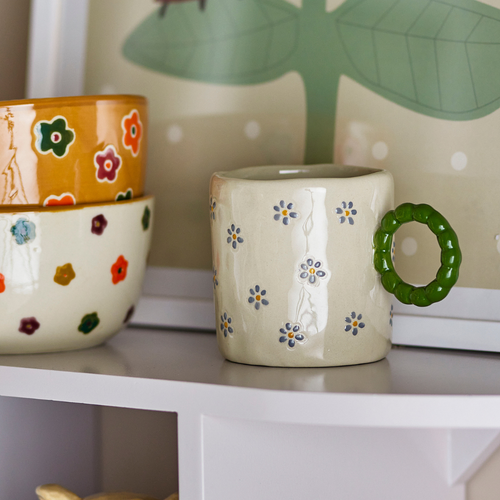 Cup with a green handle and small flowers inside decoration 
