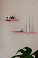 Wandregal LENN in modernem Design, rosa Farbe mit dekorativen Elementen wie Kerzen und Geschirr.