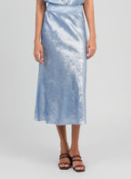 An'ge – Falda larga Janymala Indigo, falda midi satinada azul claro llevada por una modelo de frente