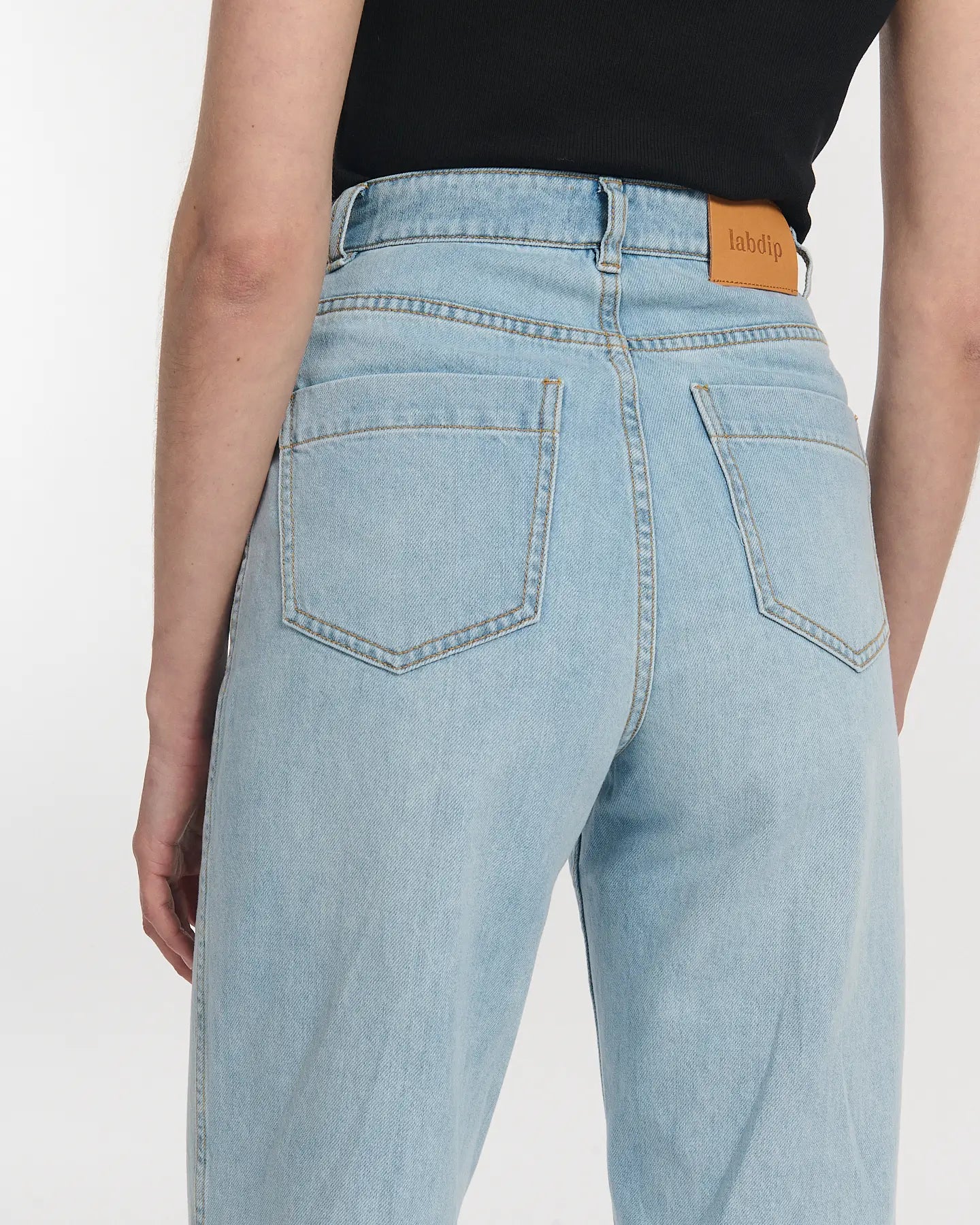 Jean droit en denim bleu clair 100 % coton avec taille haute et coupe large, s'adaptant parfaitement à toutes les morphologies féminines.