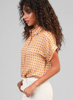 An'ge – Chemise Kacilia Domini Ble, mannequin de profil portant une chemise à motifs géométriques orange et bordeaux