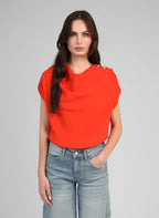 An'ge – Top Kiline Peperoncino, modella che indossa un top arancione e jeans azzurri
