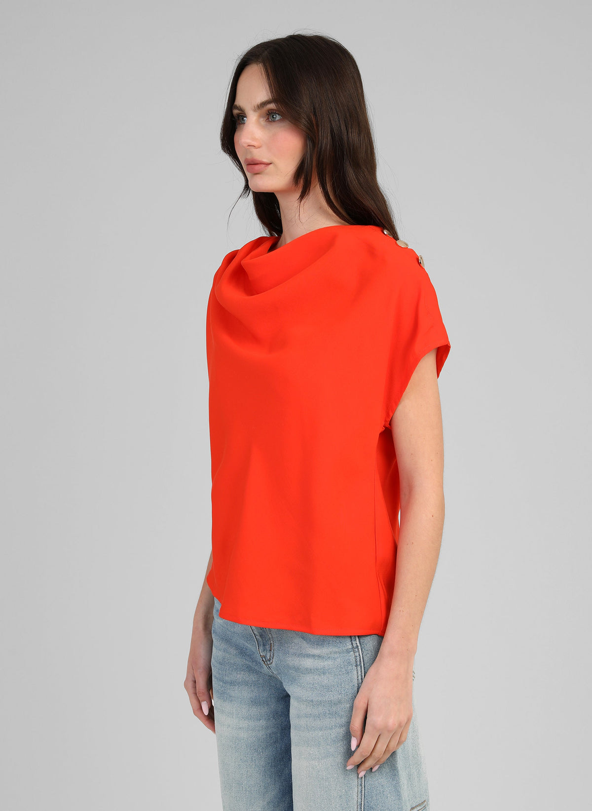 An'ge – Top Kiline Peperoncino, modella che indossa un top rosso con scollo a cappuccio, vista di profilo