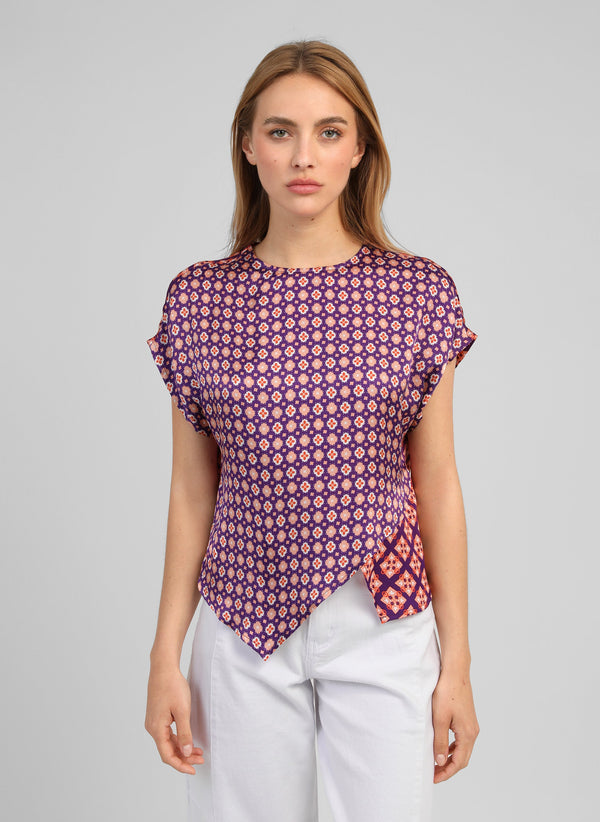 An'ge – Top Kleor Domini Encre, mannequin portant un haut violet à motifs géométriques et pantalon blanc