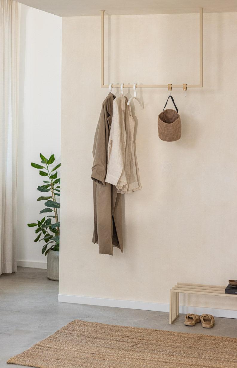 Kleiderstange RUBI mit minimalistischer Form, Kleidung und Taschen an der Wand hängend, moderner Ankleidebereich.