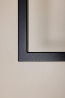 Detailansicht des schlichten schwarzen Rahmens an einer hellen Wand.