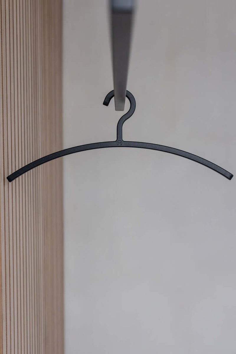 Schwarzer Kleiderbügel FAY cuelga un armario, diseño minimalista para la estética moderna.