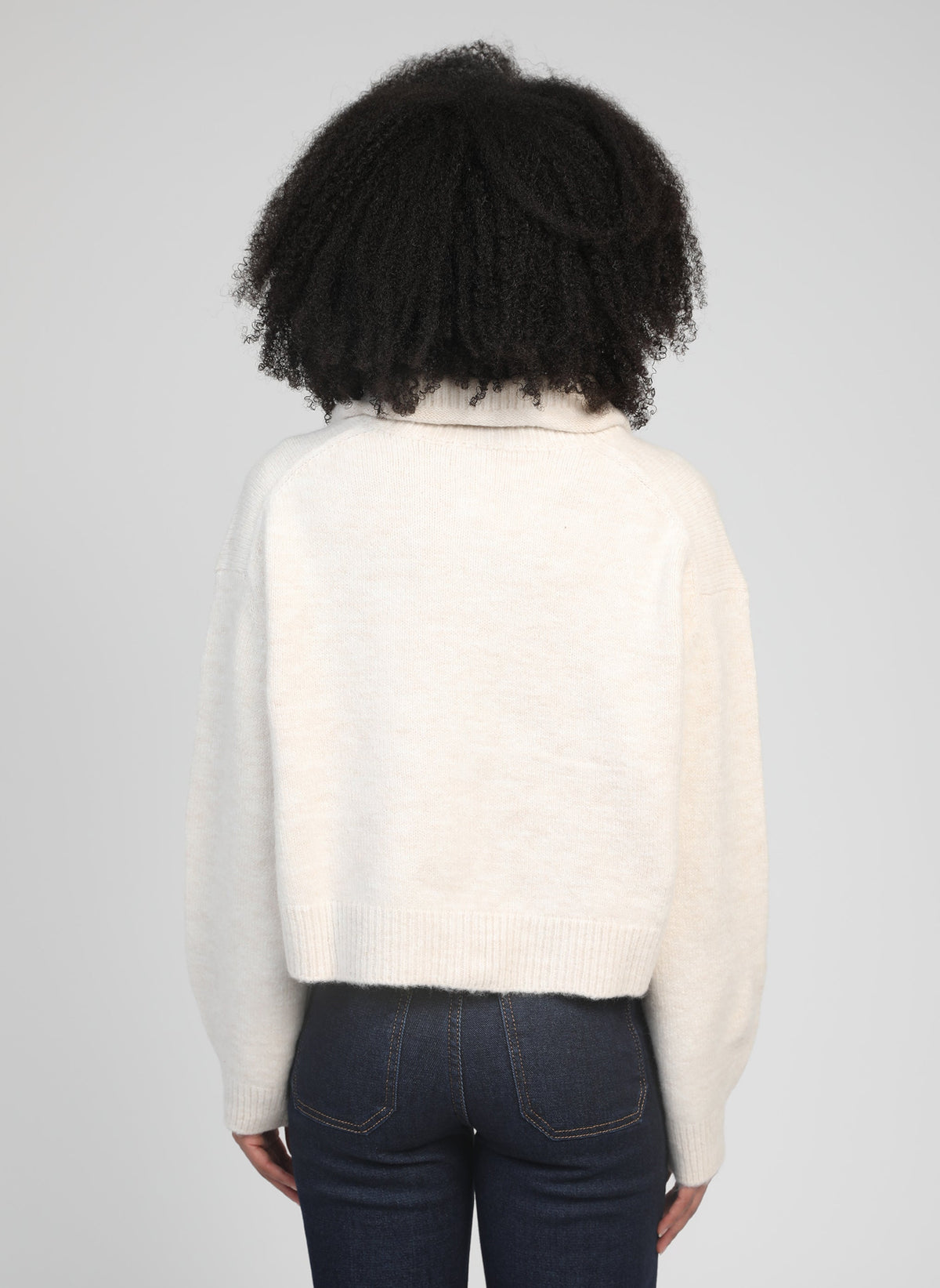 An'ge – Gilet Lakeyla Ecru, mannequin de dos portant un pull crème en maille et un jean foncé
