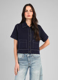 An'ge – Chaqueta Lebilly Marino, modelo llevando una camisa corta azul marino con pespuntes blancos