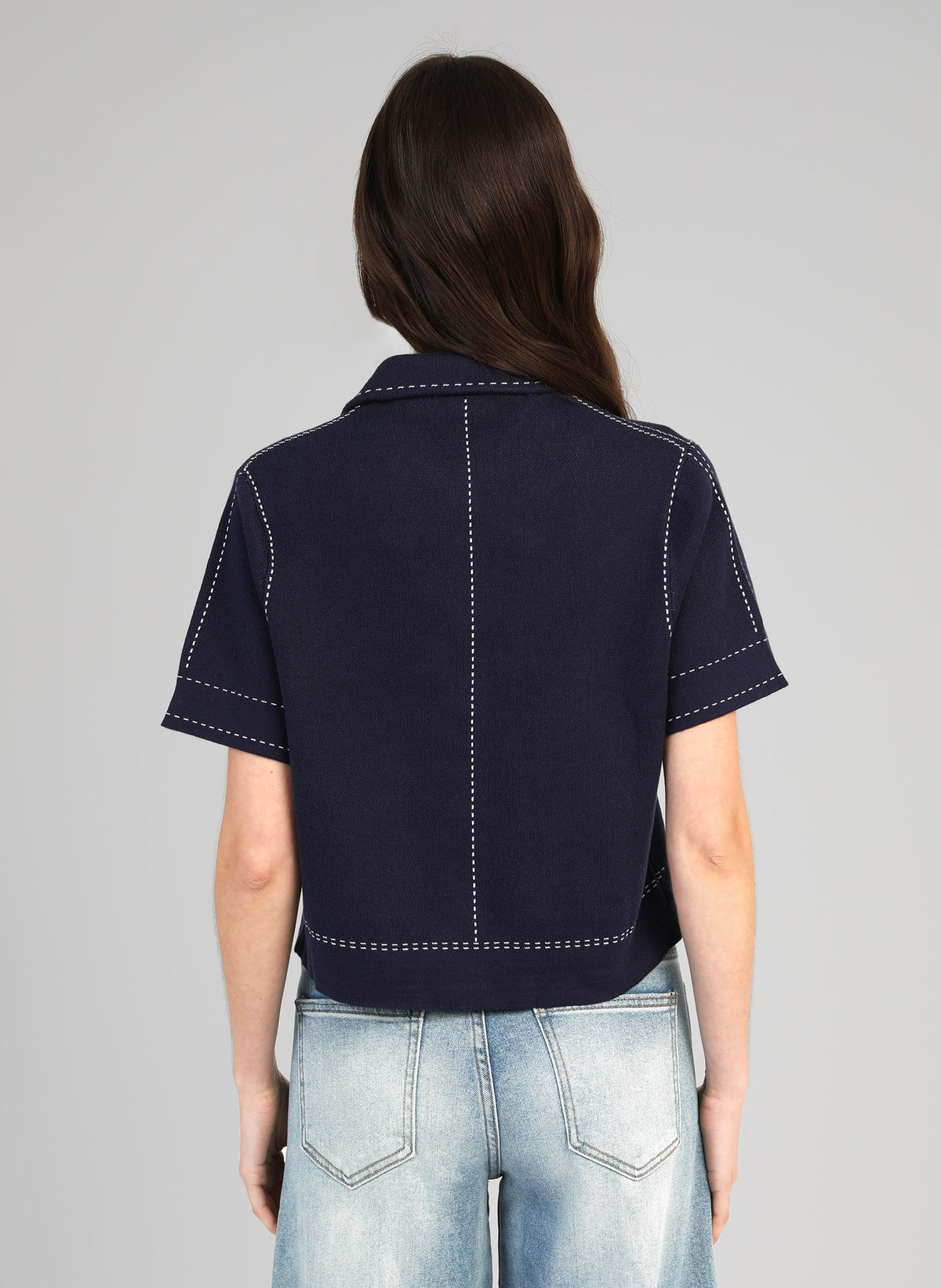 An'ge – Chaleco Lebilly Marino, modelo de espaldas con top azul marino con pespuntes blancos