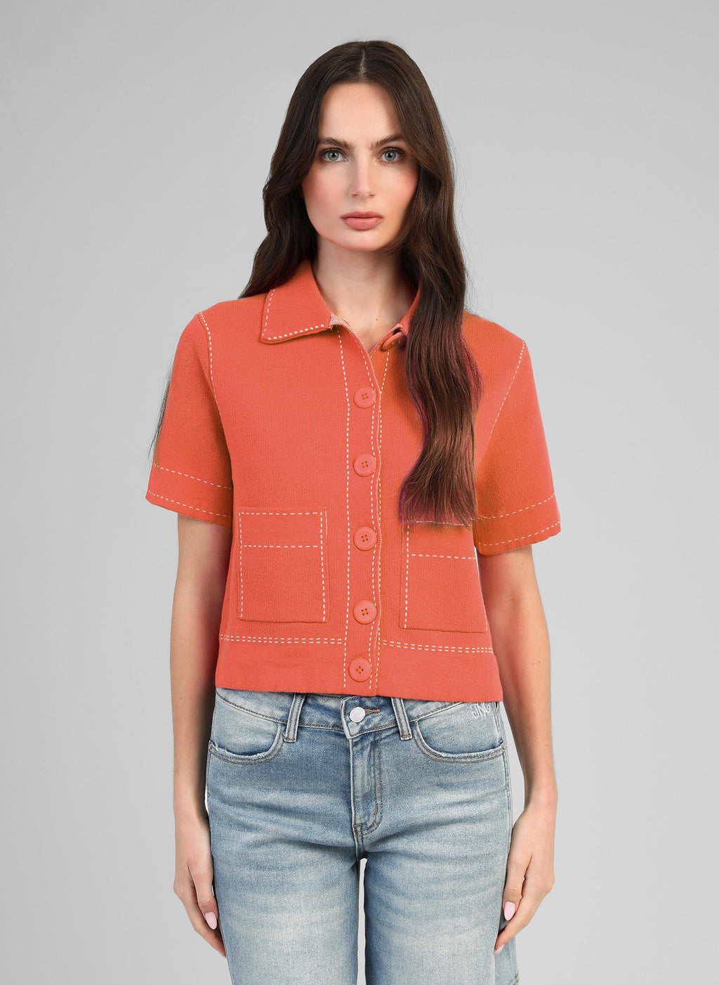 An'ge – Gilet Lebilly Piment, mannequin portant une chemise orange en maille avec des surpiqûres blanches