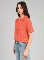 An'ge – Gilet Lebilly Piment, mannequin portant une chemise courte orange avec surpiqûres blanches, vue de profil