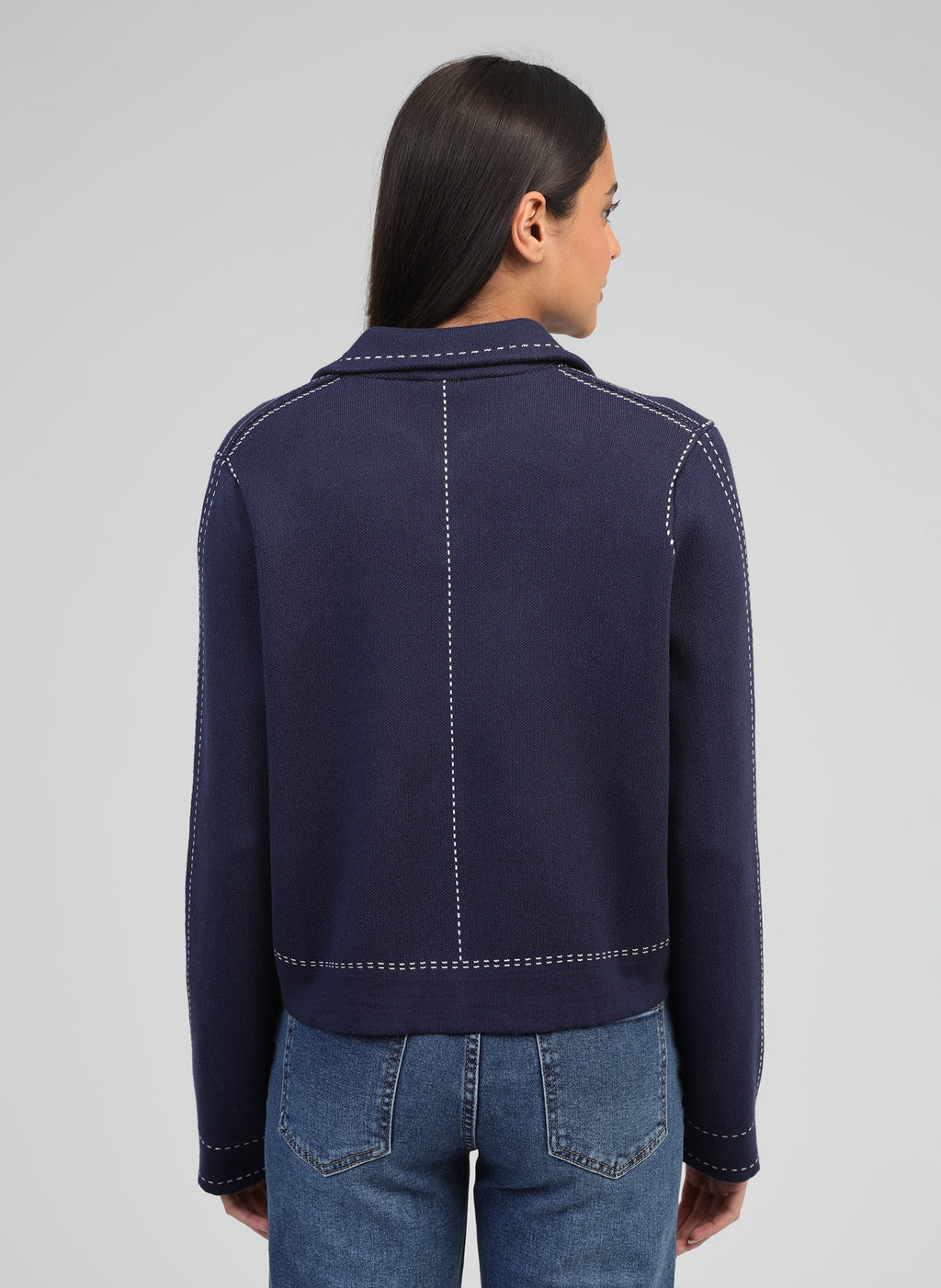 An'ge – Vest Leclint Marine, model op de rug gezien in een marineblauw jasje met witte stiksels