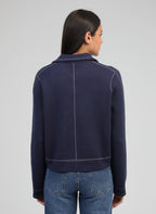 An'ge – Vest Leclint Marine, model op de rug gezien in een marineblauw jasje met witte stiksels