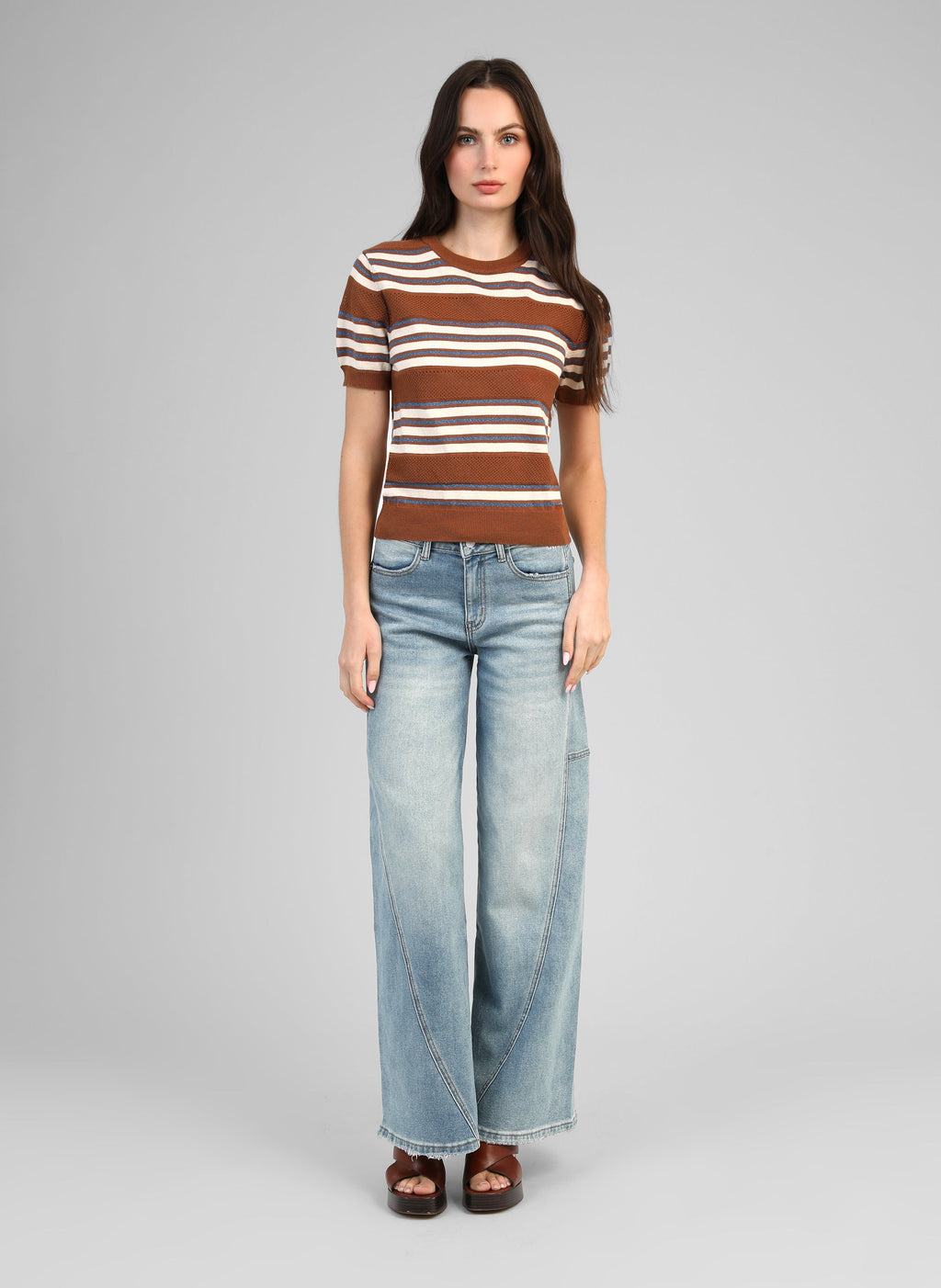 An'ge – Pantalon Palide Bleu, mannequin portant un pull rayé marron et un jean large bleu clair