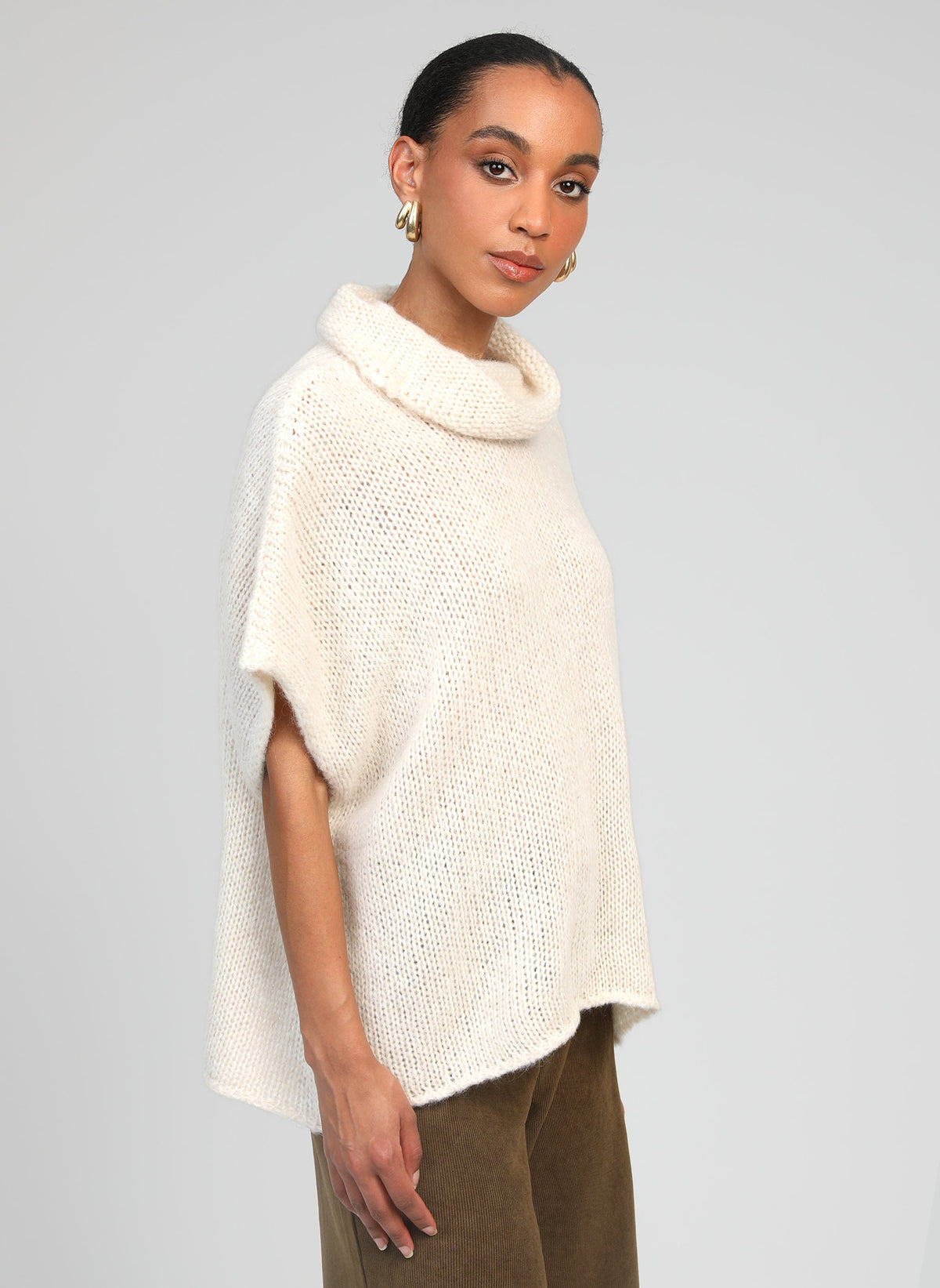 An'ge – Pull Loko Ecru, mannequin portant un pull poncho écru en maille, vue de côté