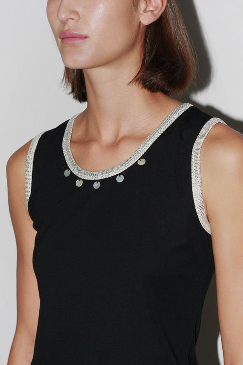 Primer plano del Top Jade: top negro sin mangas con escote adornado con perlas y corte elegante.