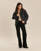 Jean pour femme en denim noir charbon, coupe bootcut ajustée et légèrement évasée, avec une matière confortable et épurée qui s’adapte à toutes les morphologies.
