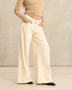 Jean femme en denim écru clair, coupe large et fluide avec taille haute, confectionné en coton épais pour un confort optimal et un style décontracté.