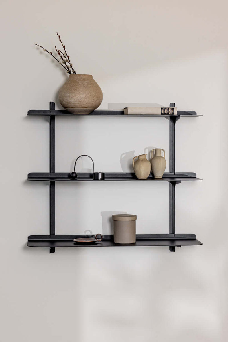 Wandregal LINARA aus Metall mit minimalistaische Design und vier Ablagen, dekoriert mit Vasen und Büchern.