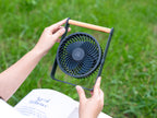 Gingko Design – Ventilador Portátil Lyra - Gris Espacial, ventilador portátil negro con asa de madera, sostenido con las manos