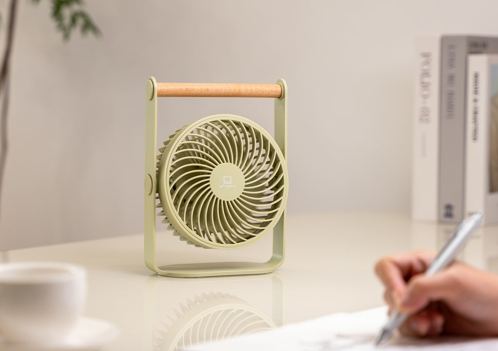 Gingko Design – Draagbare ventilator Lyra - Olijfgroen, groene tafelventilator met houten handvat, op een bureau