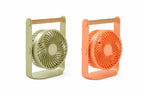 Gingko Design – Tragbarer Ventilator Lyra - Pfirsich, zwei tragbare Ventilatoren, einer grün und einer orange, auf weißem Hintergrund