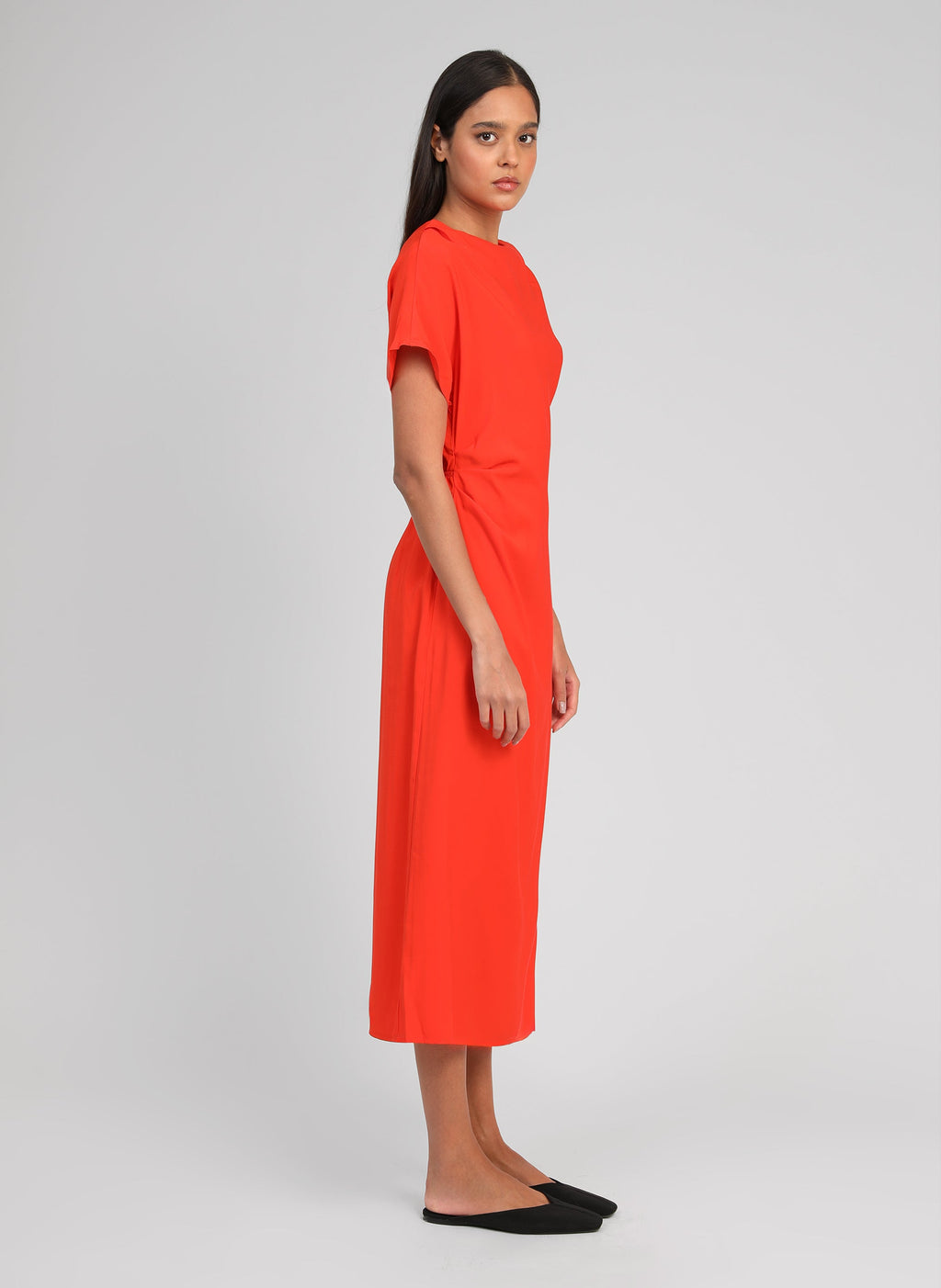 An'ge – Midi-jurk Malixa Piment, model gekleed in een felrode midi-jurk, zijaanzicht