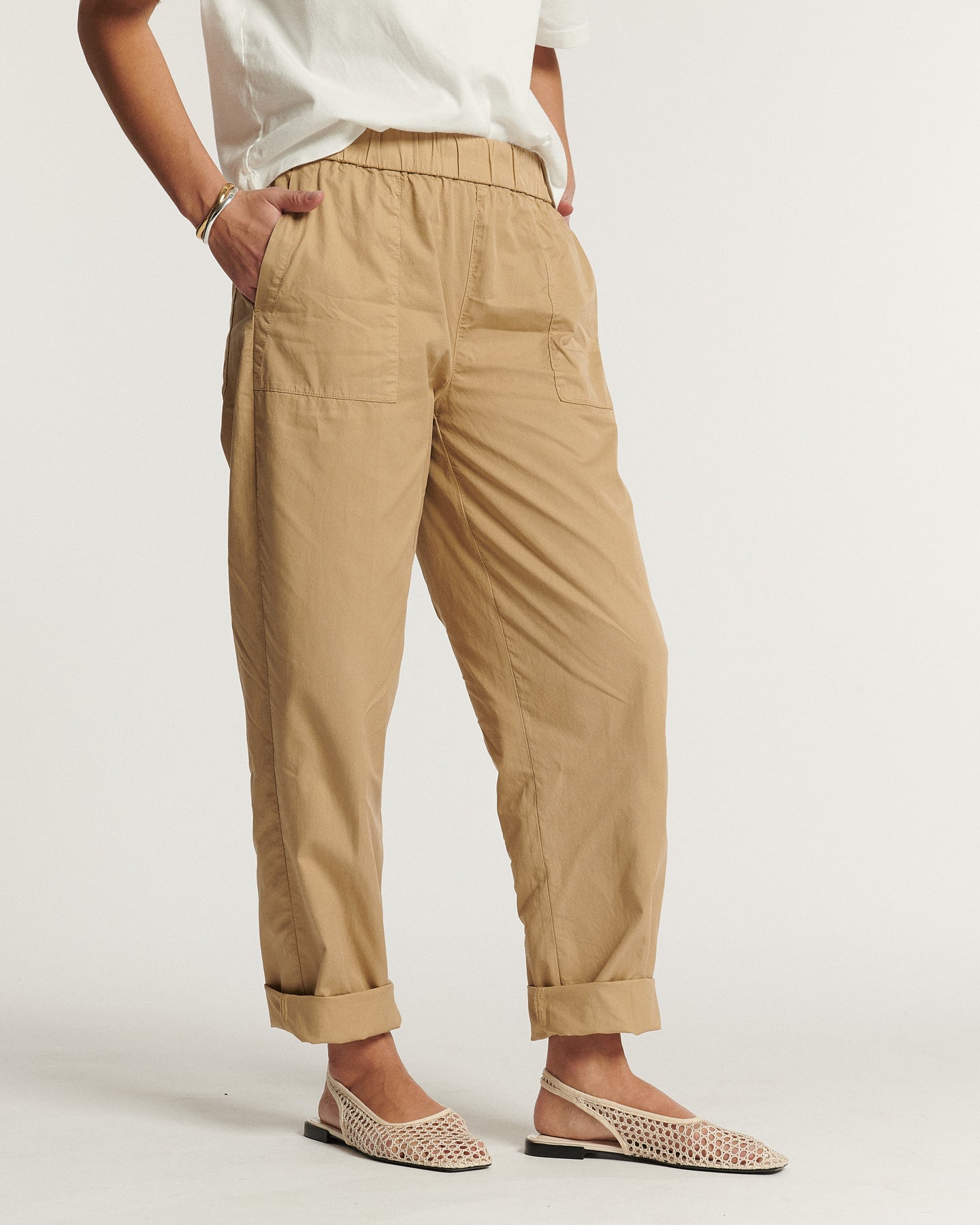 Pantalon en popeline couleur praline, coupe décontractée avec taille élastique et revers aux chevilles, matière légère et confortable adaptée à toutes les morphologies féminines.
