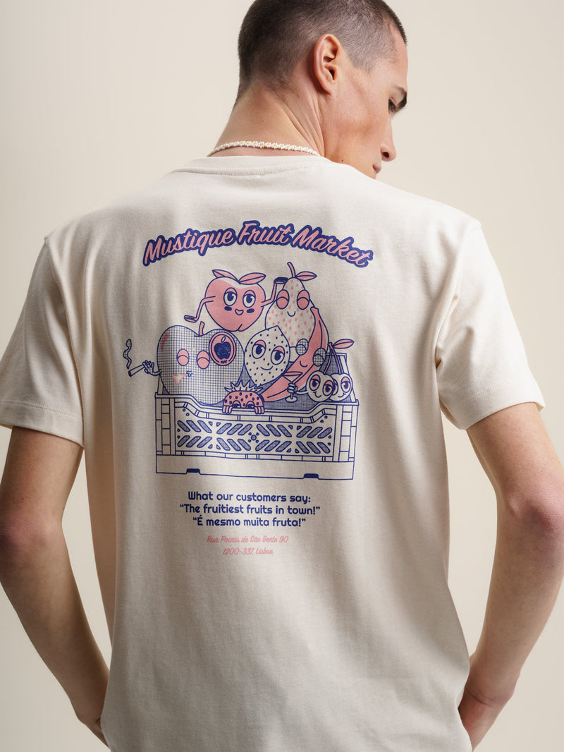 A man wearing an ecru t-shirt with a cartoon image of a man and a woman, representing a fruit market design.