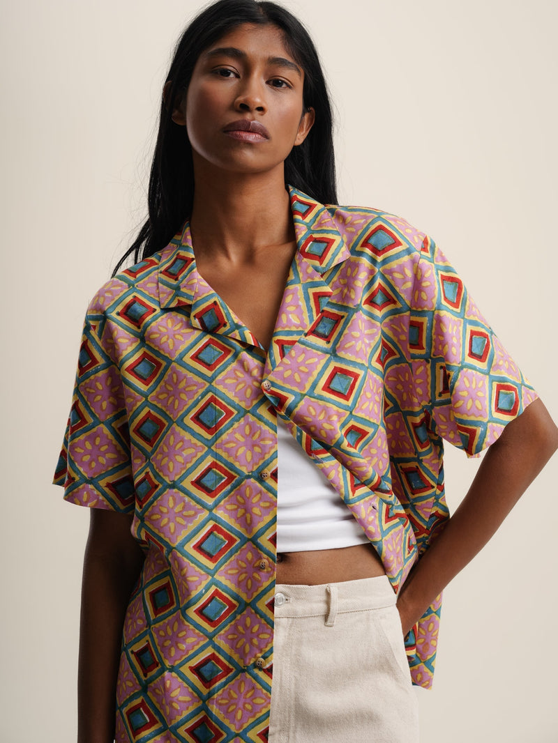 The model wears an IBIZA SHIRT with a vibrant geometric print, adding a pop of color to their outfit.