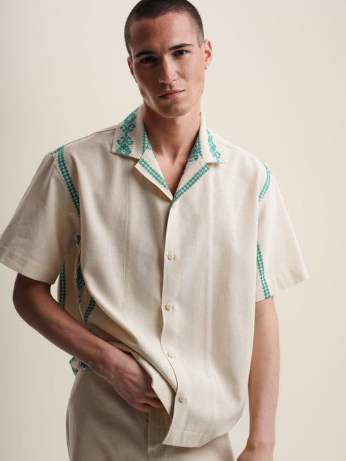 Green folklore short sleeve shirt with intricate patterns and vibrant colors. Perfect for a casual yet stylish look.