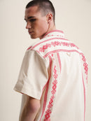 Man wearing white shirt adorned with red embroidery, RED FOLKLORE SHORT SLEEVE SHIRT.