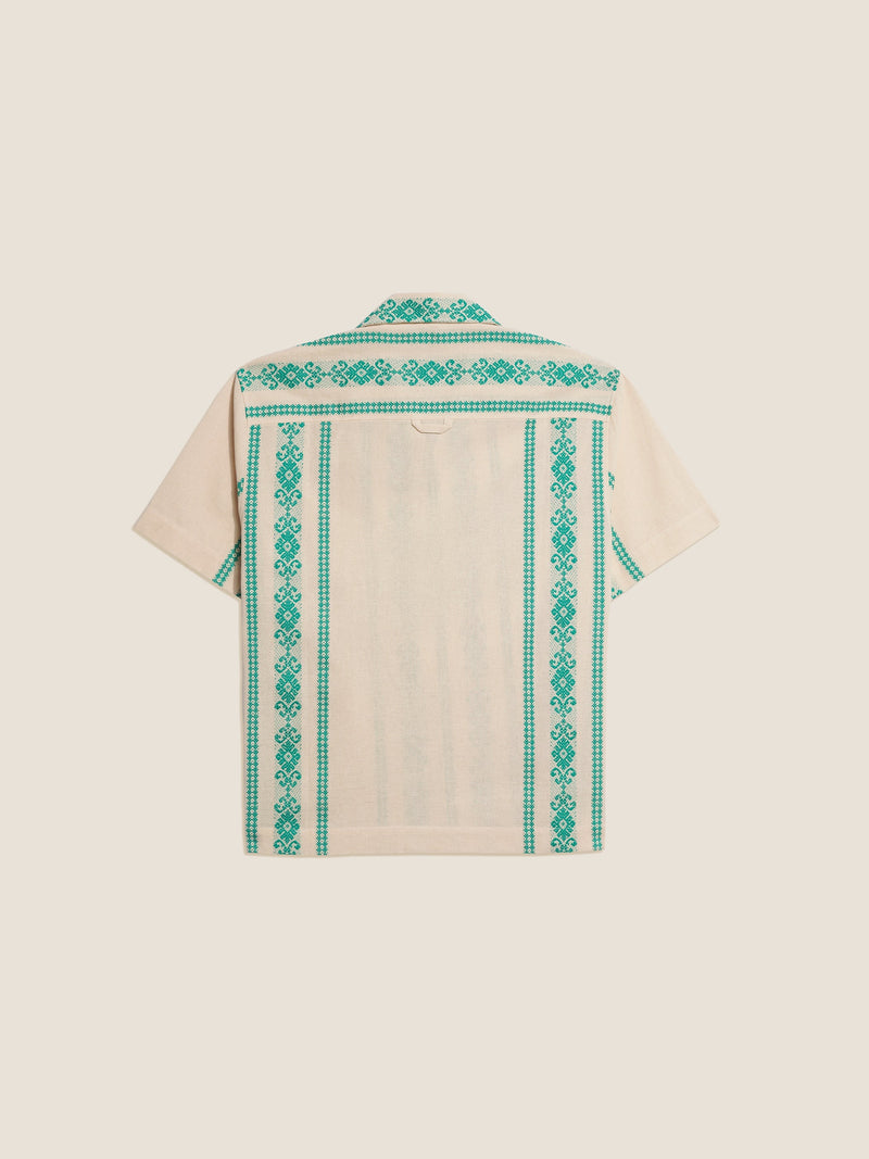 A green folklore short sleeve shirt made from a cotton and linen blend.